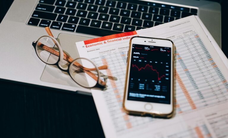 A detailed look at financial tools including a smartphone and laptop for stock analysis.