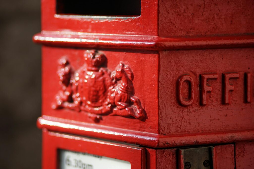 Close-up of a classic red British postbox showing intricate details and texture.
